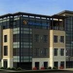 Northwestern Mutual headquarters building featuring a variety of materials on the surface in earthtones. This 4-story building has panels of glass windows and the Northwestern Mutual logo on blue on the facade.
